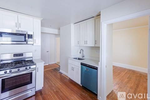 A kitchen with white cabinets and a stainless steel oven.