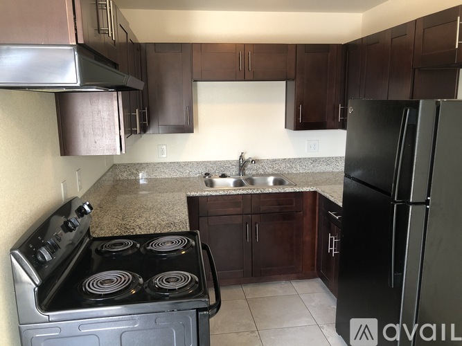 A kitchen with a black stove top oven and a black refrigerator.