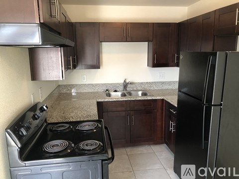 A kitchen with a black stove top oven and a black refrigerator.