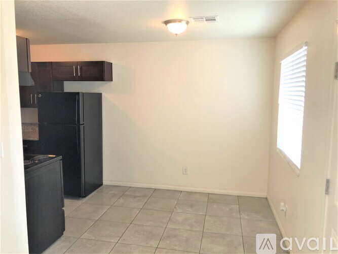 A kitchen area with black cabinets and a microwave.