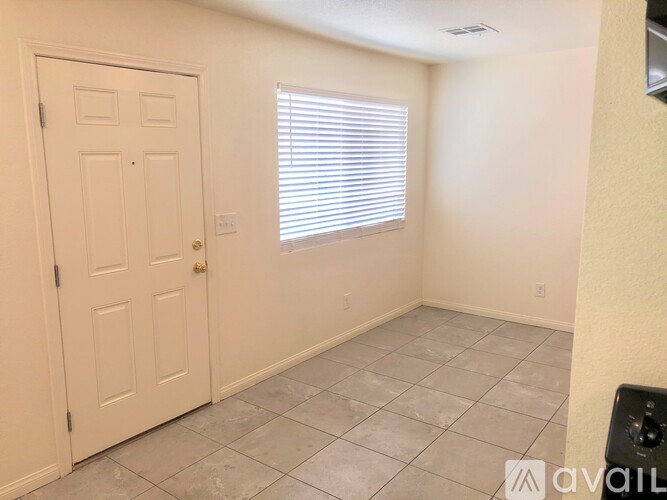 A room with a door, window, and tiled floor.