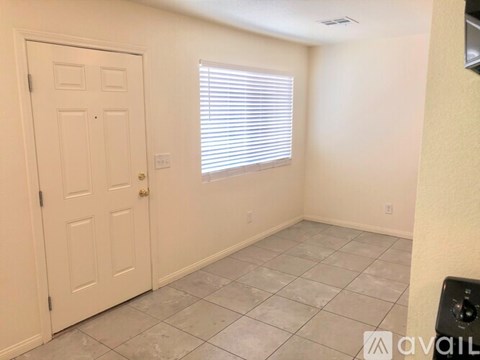 A room with a door, window, and tiled floor.