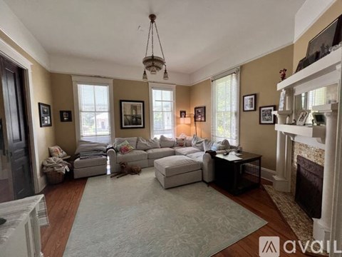 A living room with a white couch and a fireplace.