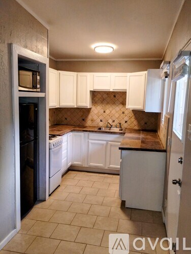A kitchen with white cabinets and a tiled backsplash.