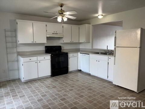 A kitchen with white cabinets and a black stove top oven.
