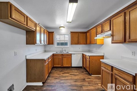 A kitchen with wooden cabinets and a white countertop.