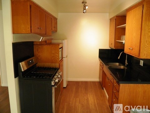 A kitchen with wooden cabinets and black countertops.