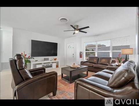 A living room with brown leather furniture and a flat screen TV.