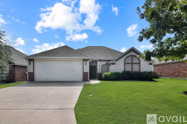 A house with a driveway and a tree in front.