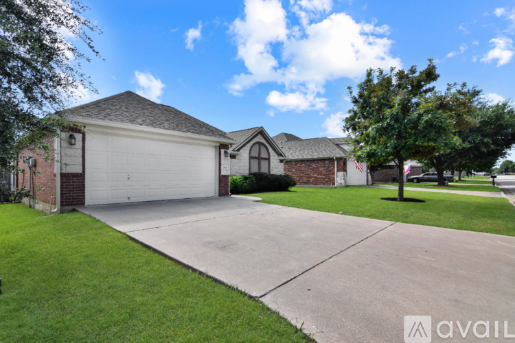 A house with a driveway and a tree in front.
