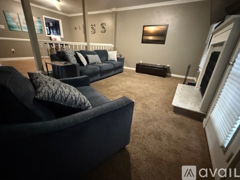 A living room with a black couch and a white radiator.