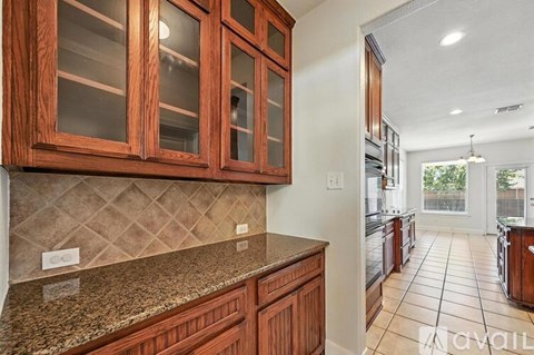 A kitchen with wooden cabinets and granite countertops.