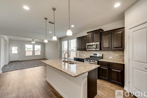 A kitchen with brown cabinets and a granite countertop.