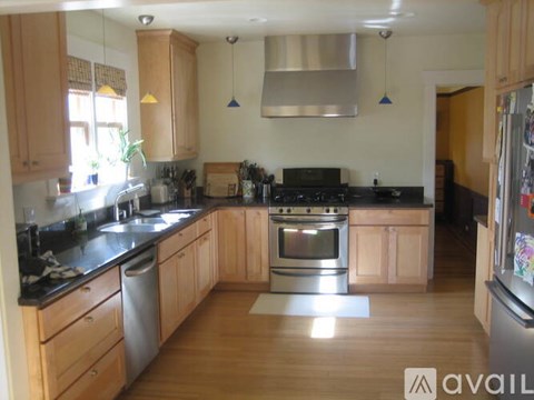 A kitchen with wooden cabinets and a black stove top oven.