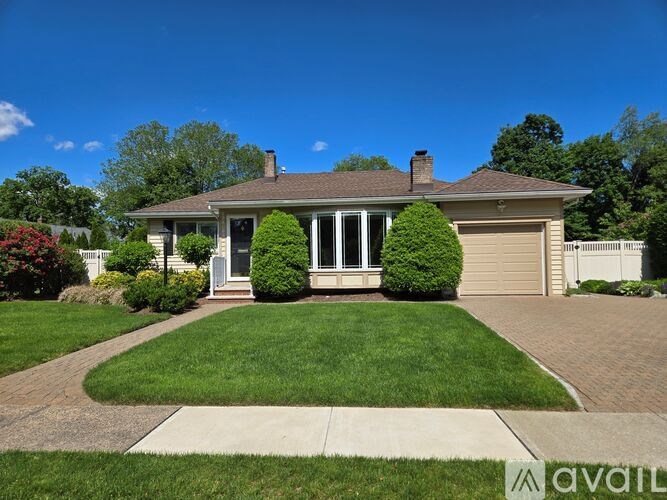 A house with a well-maintained lawn and a clear sky.