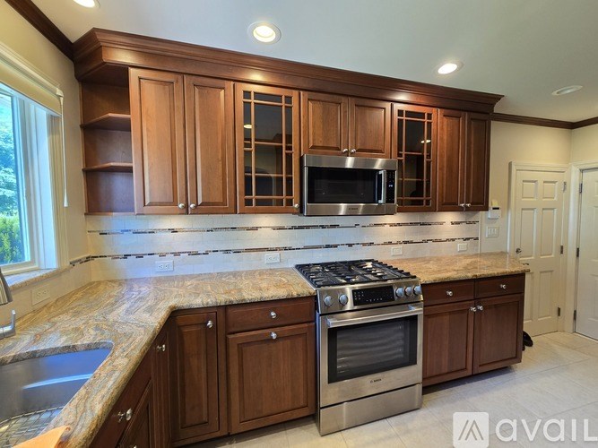A kitchen with wooden cabinets and granite countertops.