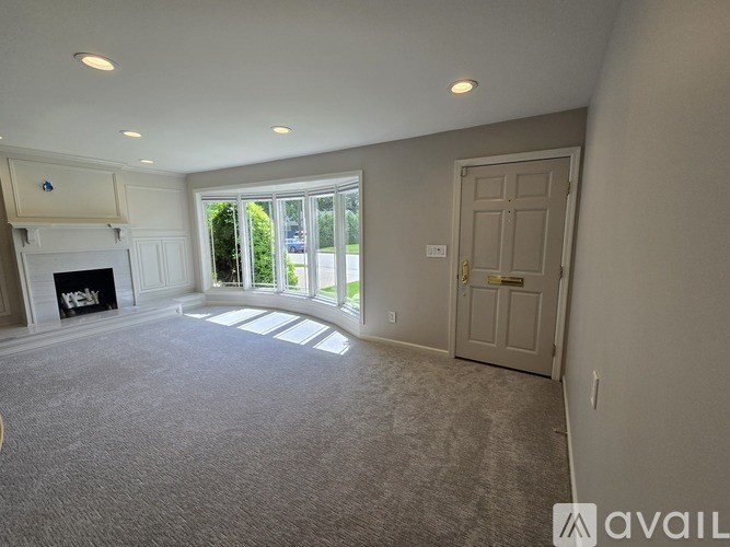 A spacious living room with a fireplace and large windows.