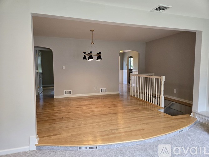 A living room with wooden floors and a chandelier.