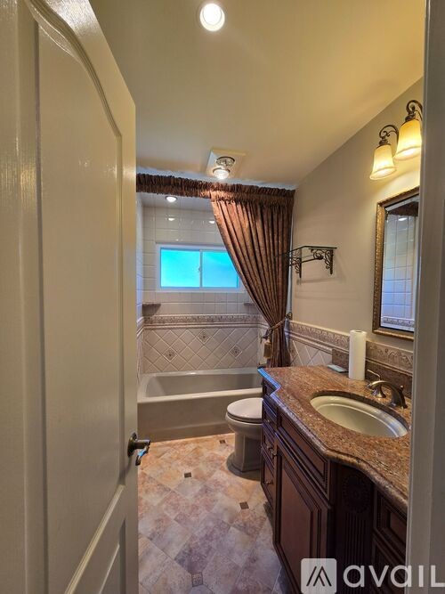 A bathroom with a tub, toilet, and sink.