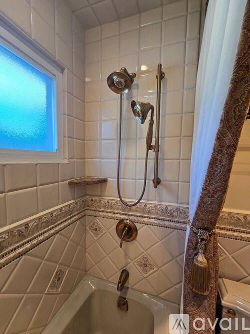 A bathroom with a shower and a window.