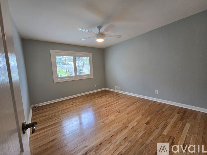 A room with a ceiling fan and a window.