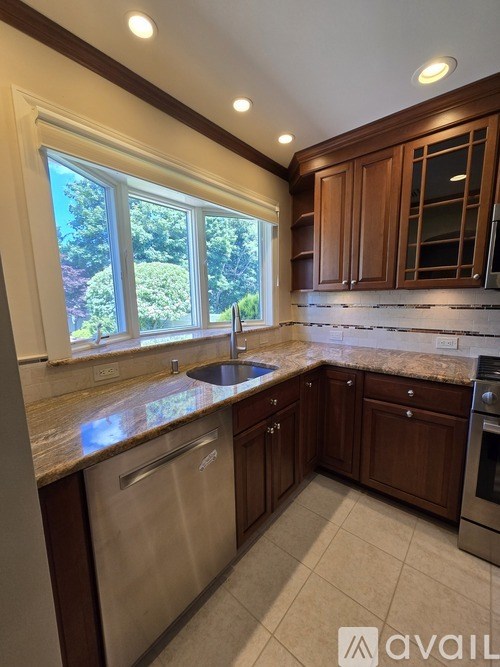 A kitchen with brown cabinets and a stainless steel dishwasher.
