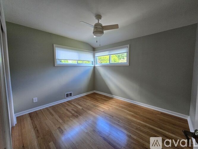 A room with a ceiling fan and a window with blinds.