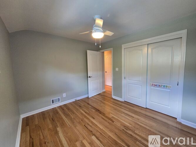 A room with wooden floors and white doors is available for rent.