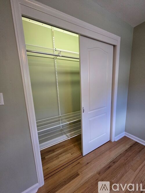 A white door with a glass window is open to a hallway.
