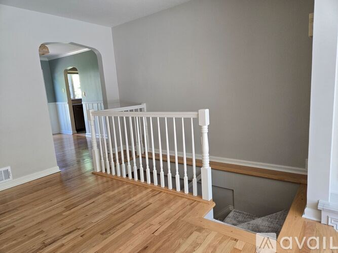 A room with a white railing and a wooden floor.