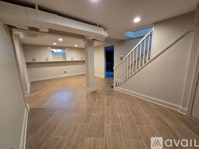 A spacious room with a staircase and a skylight.