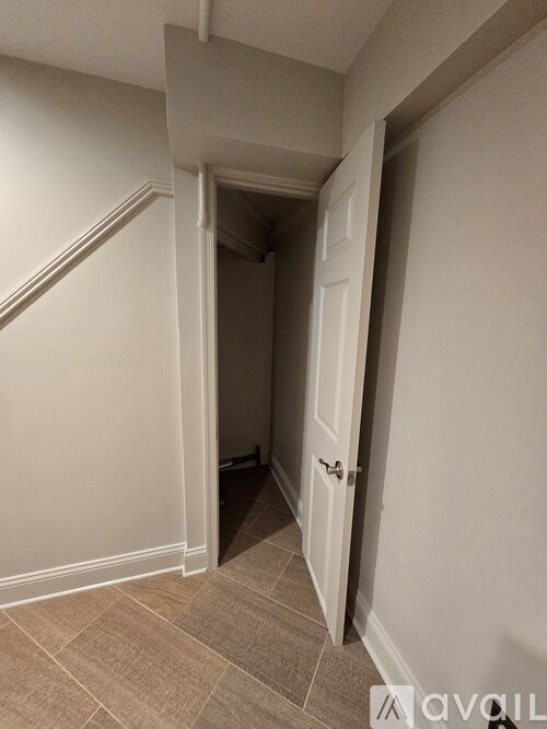 A hallway with a door on the right and a staircase on the left.