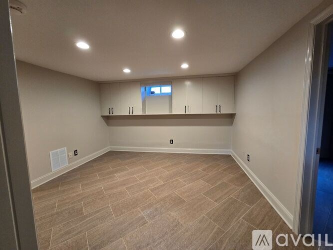 A room with a light brown floor and white walls.