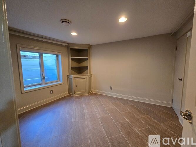 A room with a window and a door is available for rent.