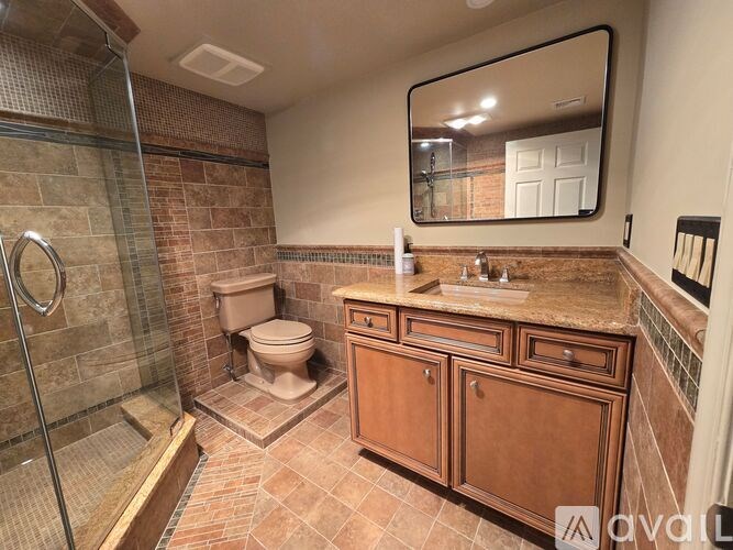 A bathroom with a toilet, sink, and shower.