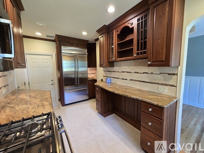 A kitchen with a granite countertop and stainless steel appliances.