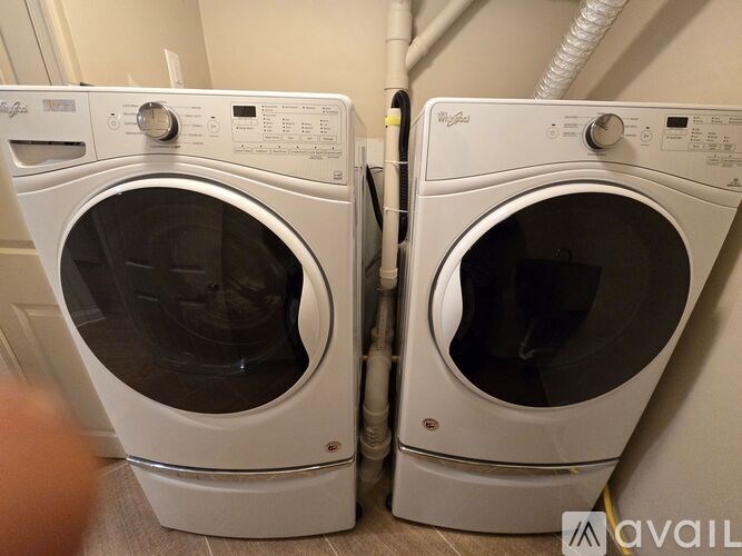 Two white washing machines are side by side.