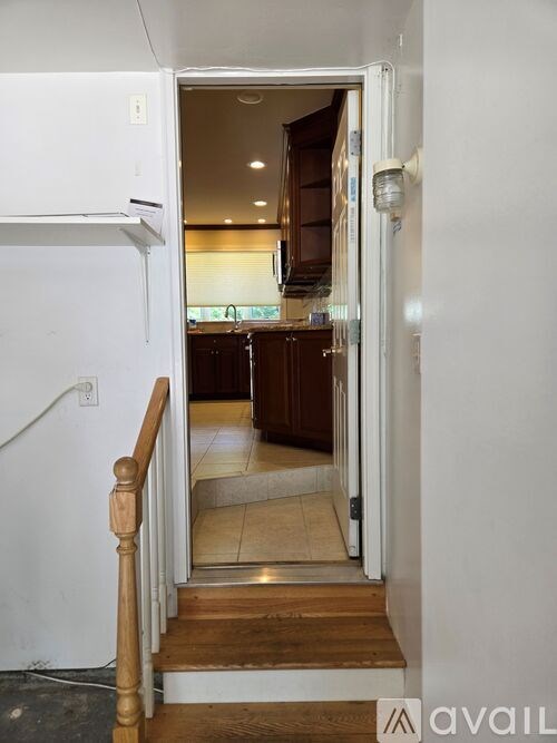 A white door is open to a kitchen.