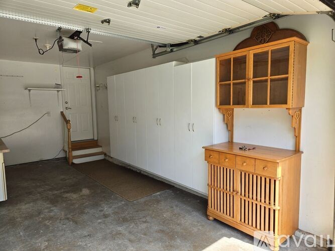 A room with a wooden cabinet and a white door.