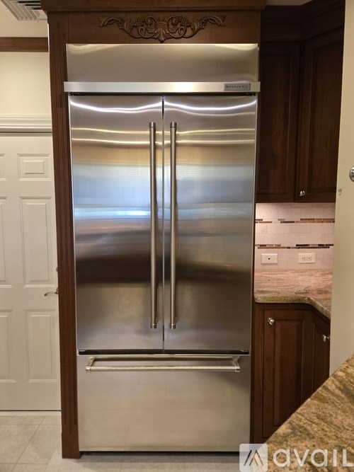 A stainless steel double door refrigerator in a kitchen.