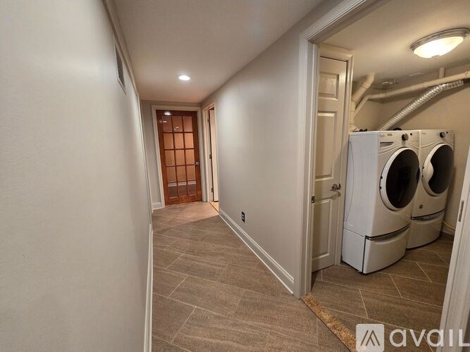 A hallway with a washer and dryer on the right side.