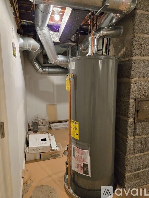 A room with a water heater and pipes.