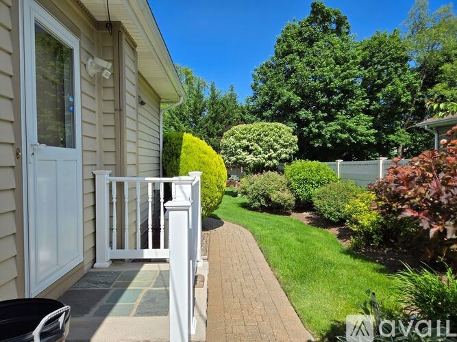 A white house with a small garden in front.