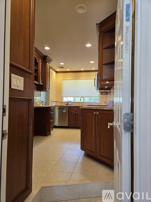 A kitchen with wooden cabinets and a white door.