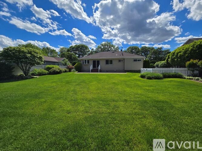 A house with a large lawn in front of it is for sale.