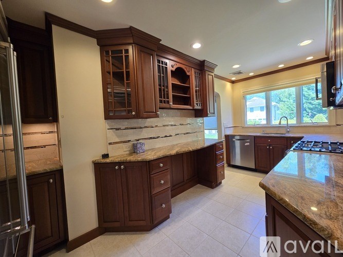 A kitchen with brown cabinets and granite countertops.
