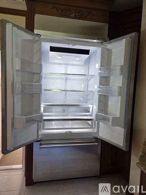 A white refrigerator with its door open and shelves visible.