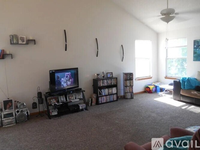 A living room with a television, speaker, and bookshelf.