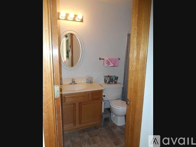 A bathroom with a toilet, sink, and mirror.