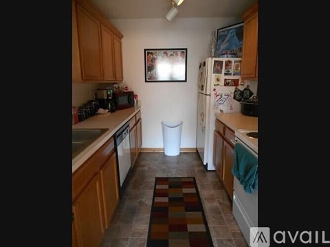 A kitchen with wooden cabinets and a white fridge.